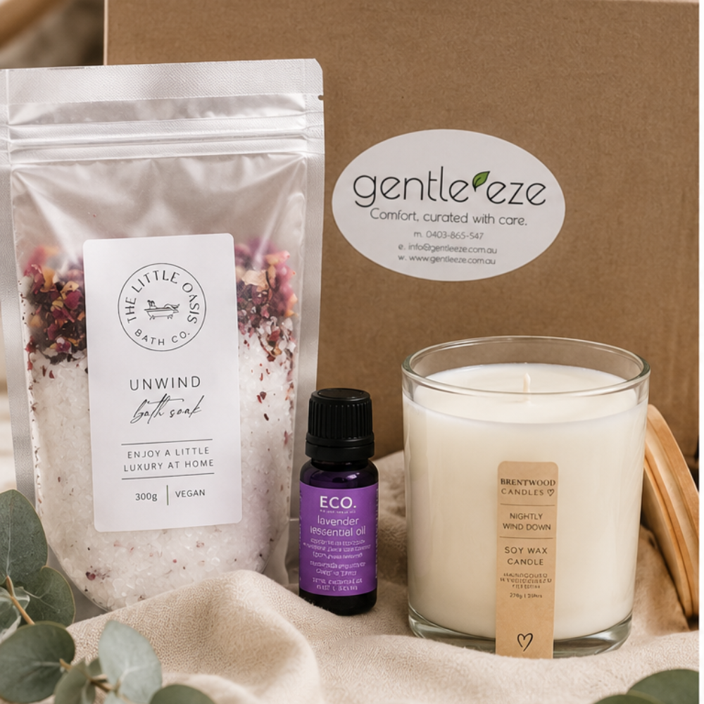 Gentle Eze product with bath soak, candle, and essential oil on a neutral background