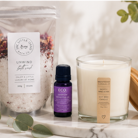 Bath salts, essential oil, and candle on a marble surface with a soft background