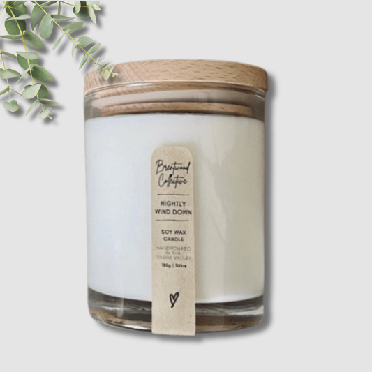Candle with a wooden lid and label on a light gray background