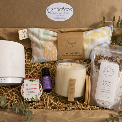 Gentleze self-care gift set with candle, eye pillow, and bath salts on a brown surface.