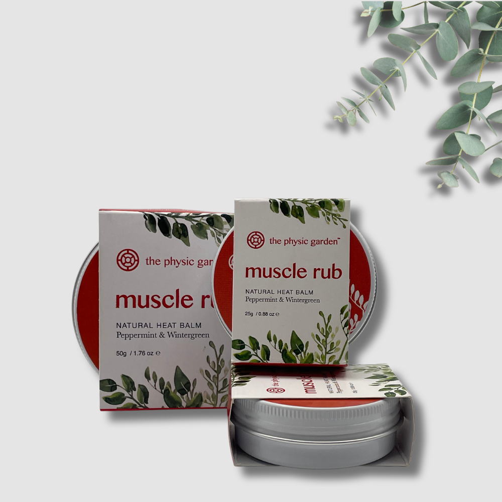 The Physic Garden muscle rub balm packaging with a white background and eucalyptus leaves.