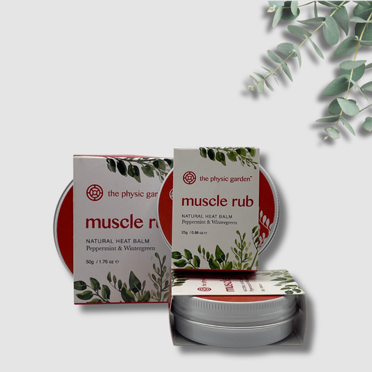 The Physic Garden muscle rub balm packaging with a white background and eucalyptus leaves.